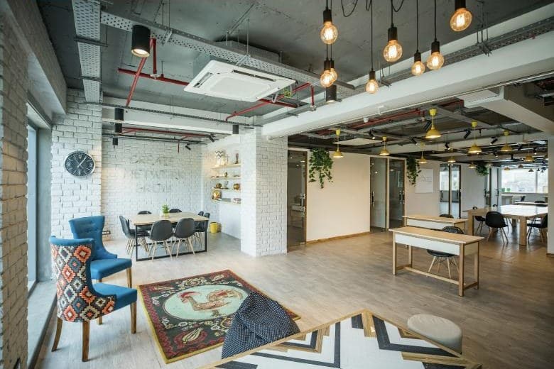 An open-plan coworking space with desks and a meeting table